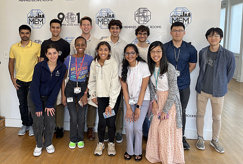 12 people stand in front of a wall