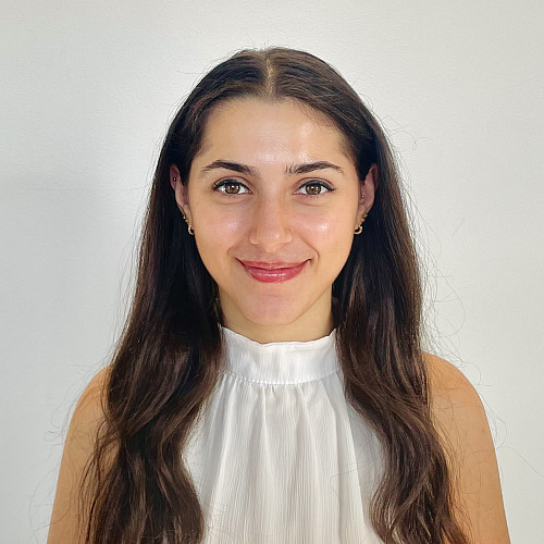 picture of a woman in a white shirt with a blank wall behind