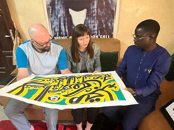     Fig. 3 Derosier, Story, and Ndiaye looking at Fall's work 