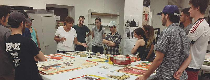 Professor Donna Oliver shows Soviet era posters and materials to students in the Wright Museum.