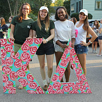 Members of Kappa Delta holding their letters while preparing for a homecoming parade.