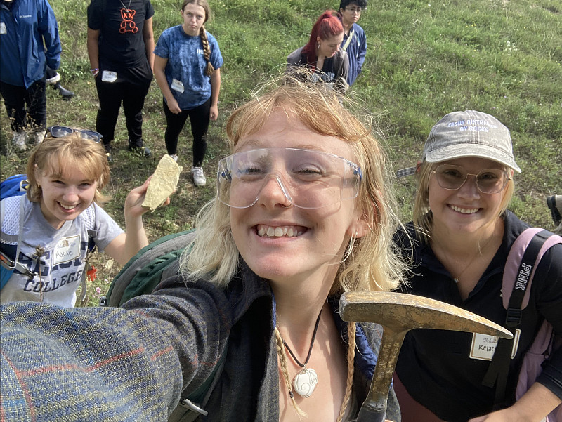 Members of the Geology Club pose together to show off their tools and a rock sample.