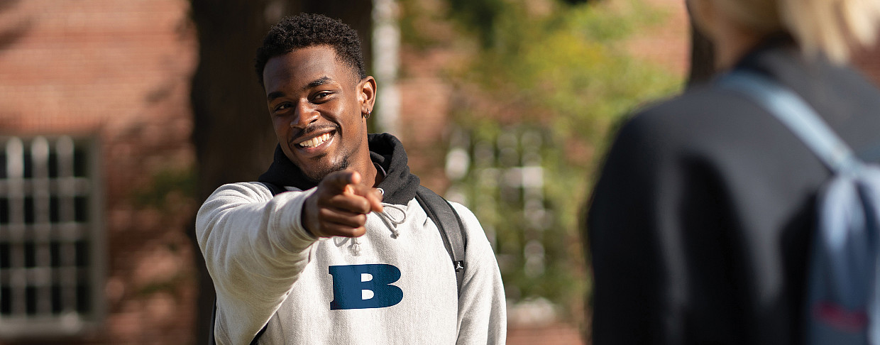 student pointing at the camera and smiling