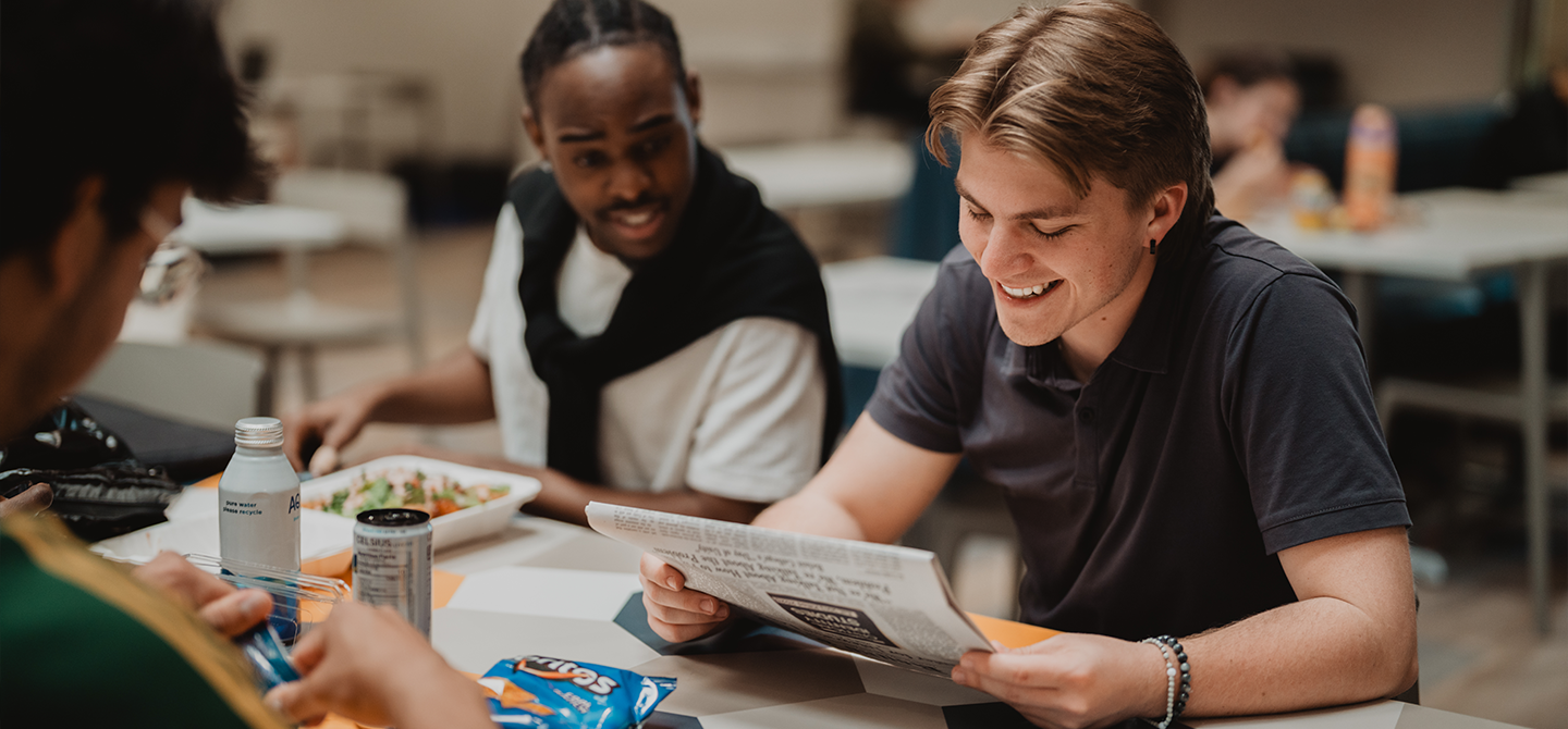 Friends reading the student newspaper.