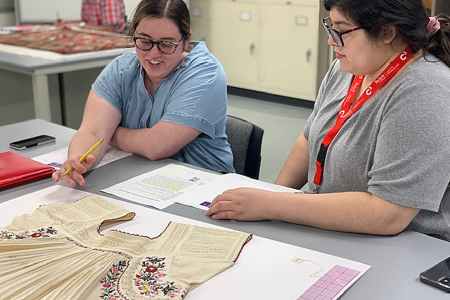 Introduction to Textile Conservation participants conducting a detailed condition report on a Mexican blouse from the Logan Museum's coll...