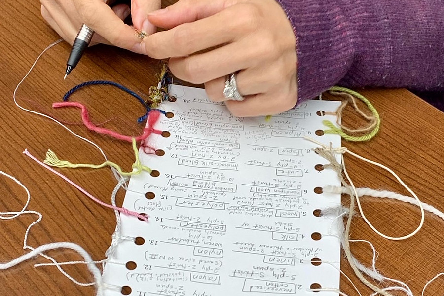 Introduction to Textile Conservation participant creating a fiber identification reference card.