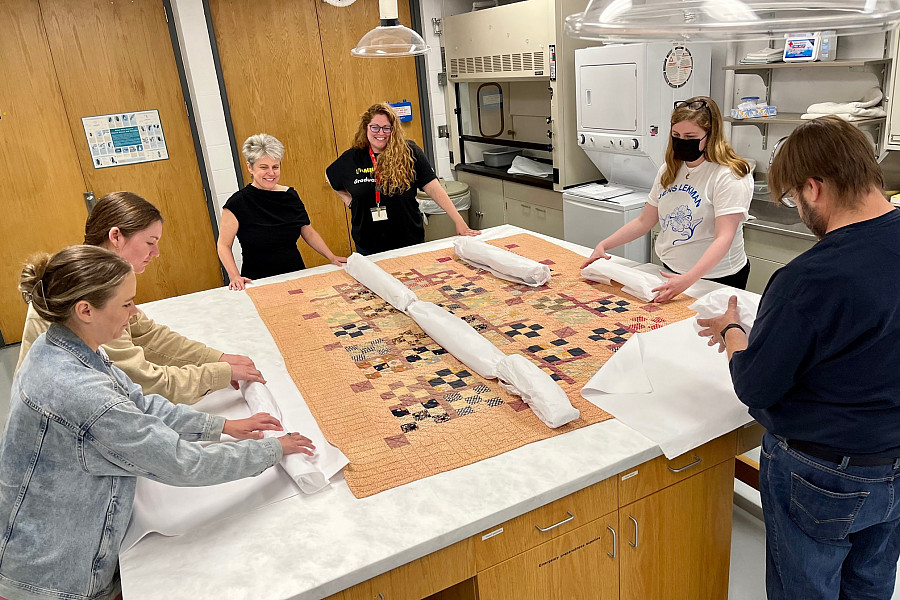 Storage Solutions participants practice folding a quilt for storage.