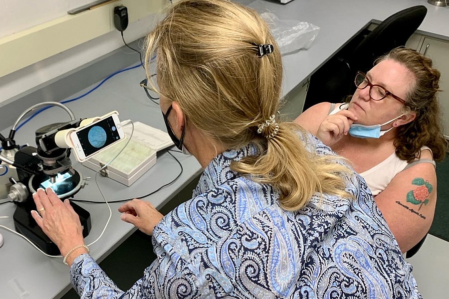 Introduction to Textile Conservation instructor, Camille Breeze, and participant examining fibers using magnification.