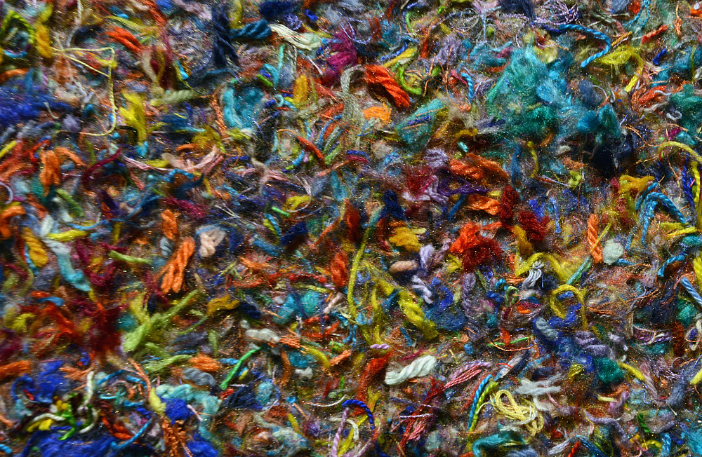 A artistic piece by Grace Zaffiro composed of a colorful mix of pieces of yarn.