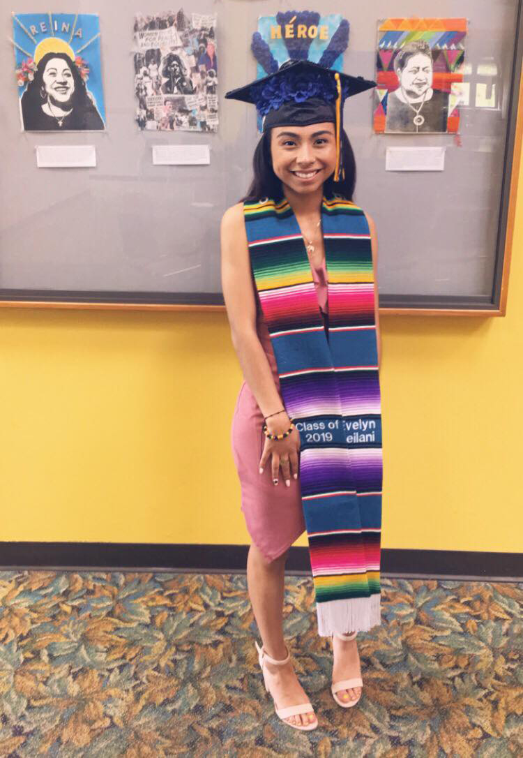 Evelyn Roman '19 stands in front of her artworks celebrating Latinx women in Pearsons.