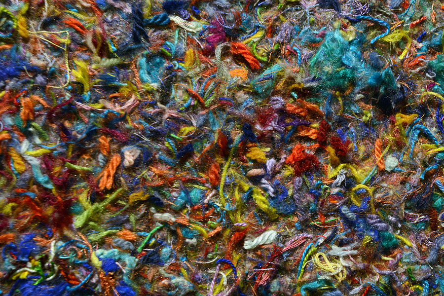 An art piece by Grace Zaffiro composed of a colorful mix of pieces of yarn, each capturing the moment it was stitched into the work.