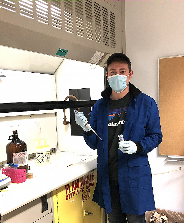 Jonathan Palmer '19 in the chemistry lab holding pipet and vial