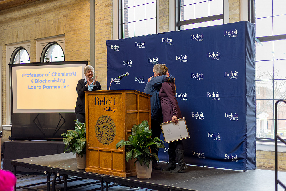 Suzanne Cox & Laura Parmentier hug on stage during the 2025 Faculty Staff Recognition ceremony.