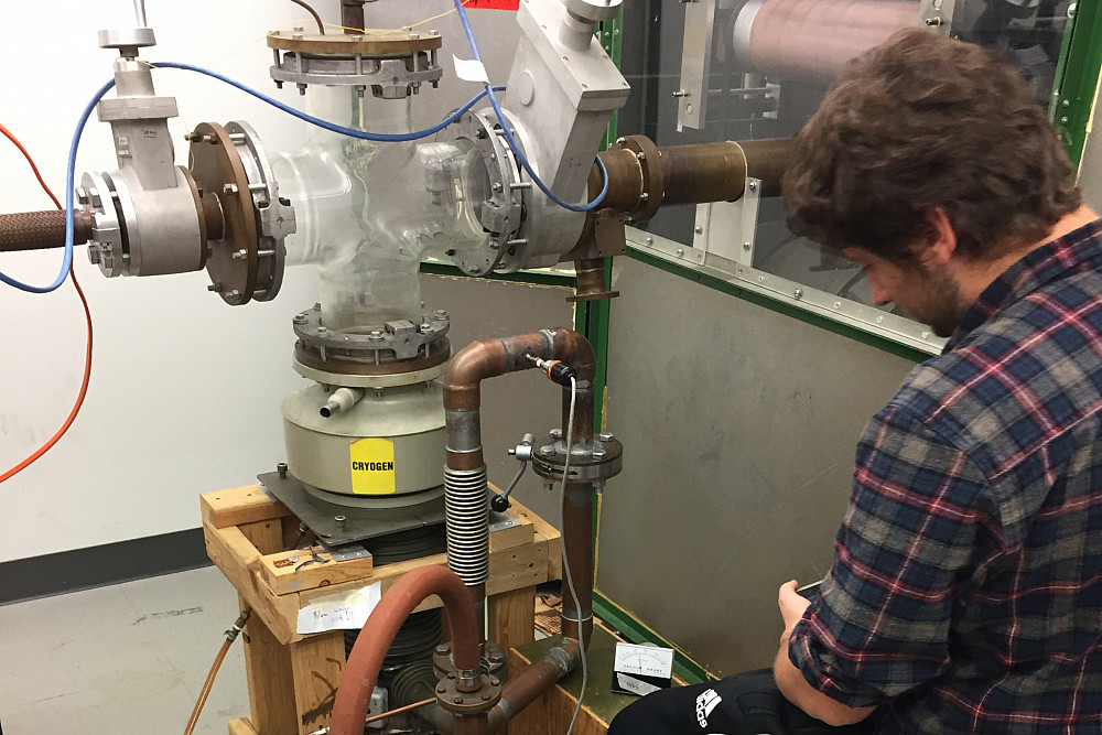 A student monitors the equipment for the particle accelerator.