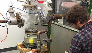 A student monitors the equipment for the particle accelerator.