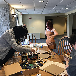 Students painting reusable totebags