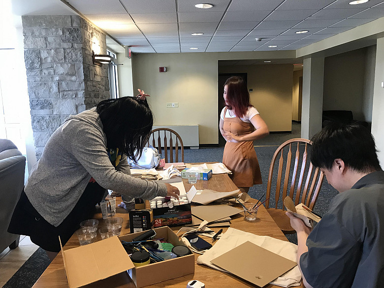 Students painting reusable totebags