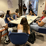 Alumni Lirio Hittle’86 (far end of the table) and Samir Goswami’98 (standing) talk with students