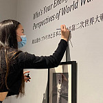 Midori Tanada ’23 touches up the vinyl for the exhibit done by students in Susan Furukawa’s “Narratives of War and Peace” Japanese class.