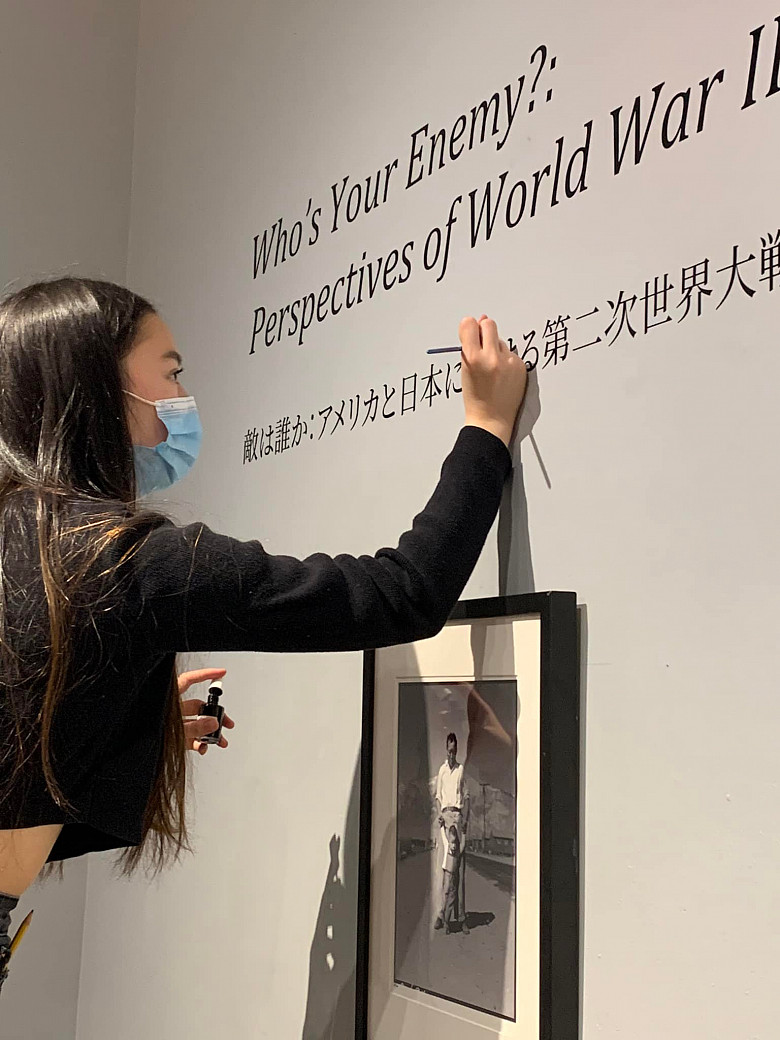 Midori Tanada '23 touches up the vinyl for the exhibit done by students in Susan Furukawa's Narratives of War and Peace Japanes...