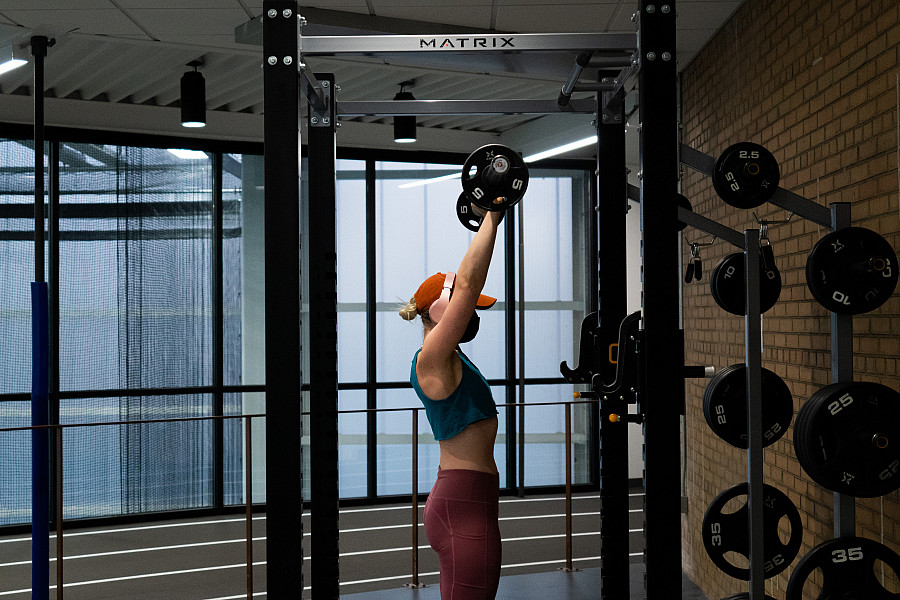 Student lifting weights on the fitness floor of the Powerhouse.