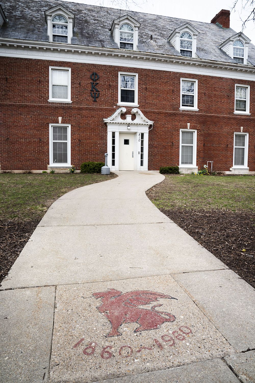 Beta Theta Pi's dragon mascot Wooglin in front of the Phi Kappa Psi fraternity house.