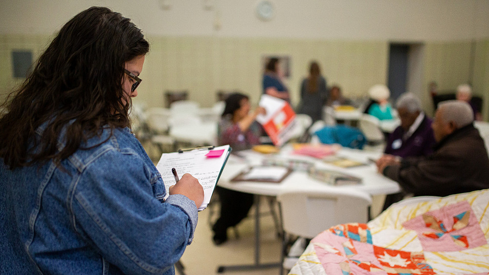 Bre Partida-Castillo'20 makes notes about a pinwheel quilt the Edmond-Elzy family brought to the History Harvest.