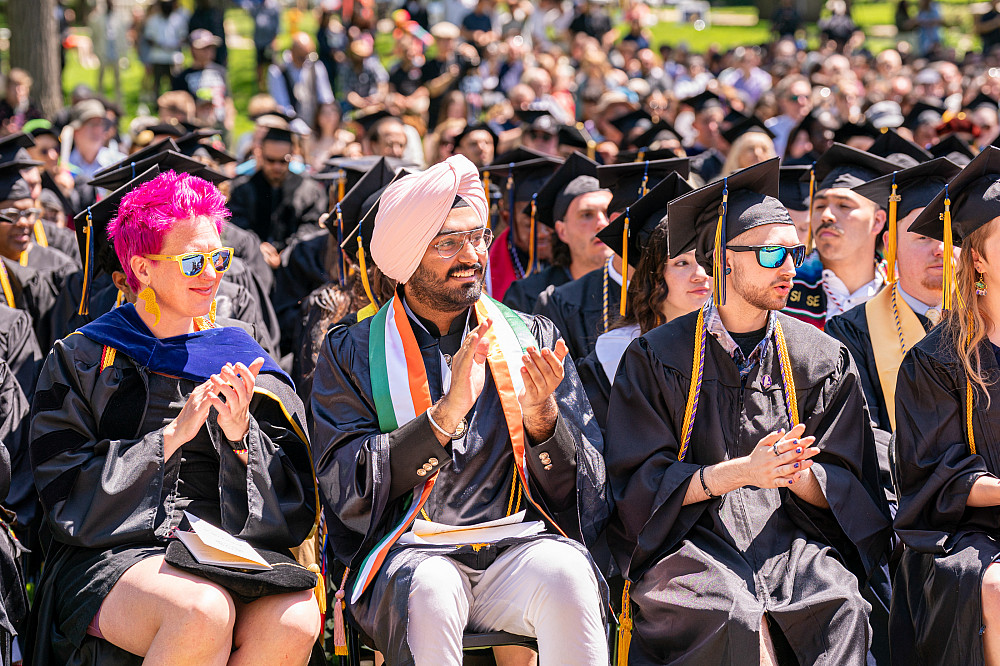 Student commencement speaker Abhey Singh Guram '25 clapping along with his peers.