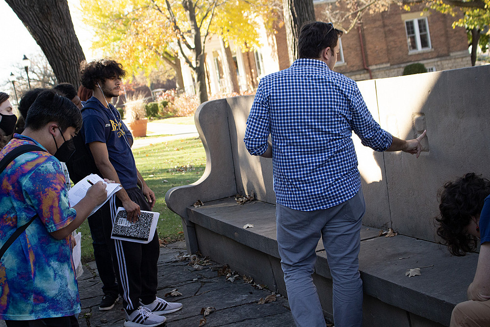 Geology professor Jay Zambito talks with students about a limestone bench on campus.