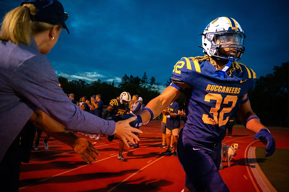 Raydarriuz Kelley'25 leads the Buccaneers onto the field for the homecoming game at Strong Stadium.
