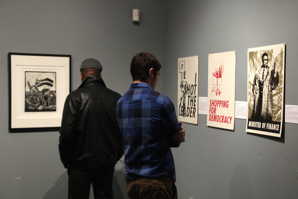 Kudzanai Chiurai, Zimbabwe/South Africa | Gallery visitors take in a series of posters created by internationally known artist Kudzanai C...