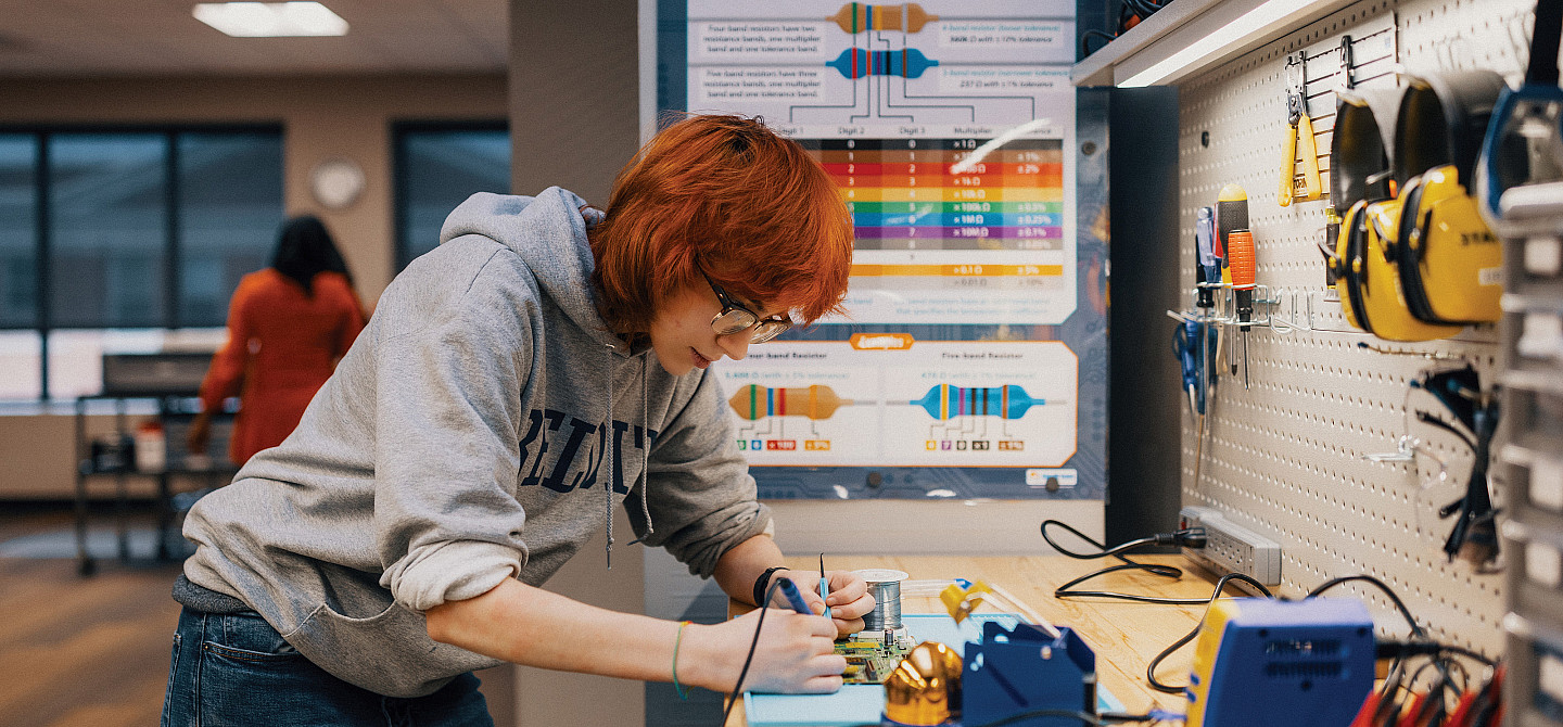 Maker Lab supervisor Adwyn Burdett'27 experiments with a motherboard.