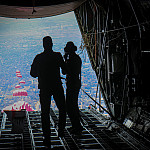 A Jordanian flight crew watches crates of food drift down to Gaza.