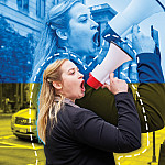 Anastasia Voronovsky'21 uses a megaphone in an urban setting.