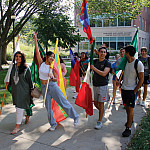 International students lead the Fall 2023 convocation parade, their country’s flag in hand.