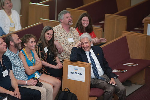 The Alumni Assembly audience, including President Bierman at right, reacts to alumni stories shar...