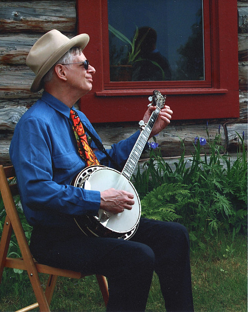 Richard Fineberg '64 in front of his cabin, playing the banjo.