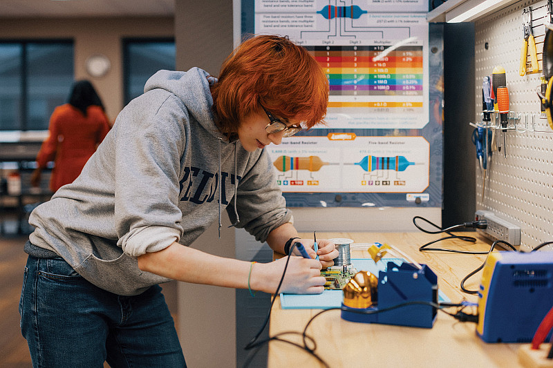 Maker Lab supervisor Adwyn Burdett'27 experiments with a motherboard.