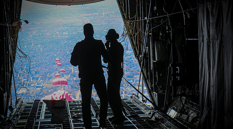 A Jordanian flight crew watches crates of food drift down to Gaza.